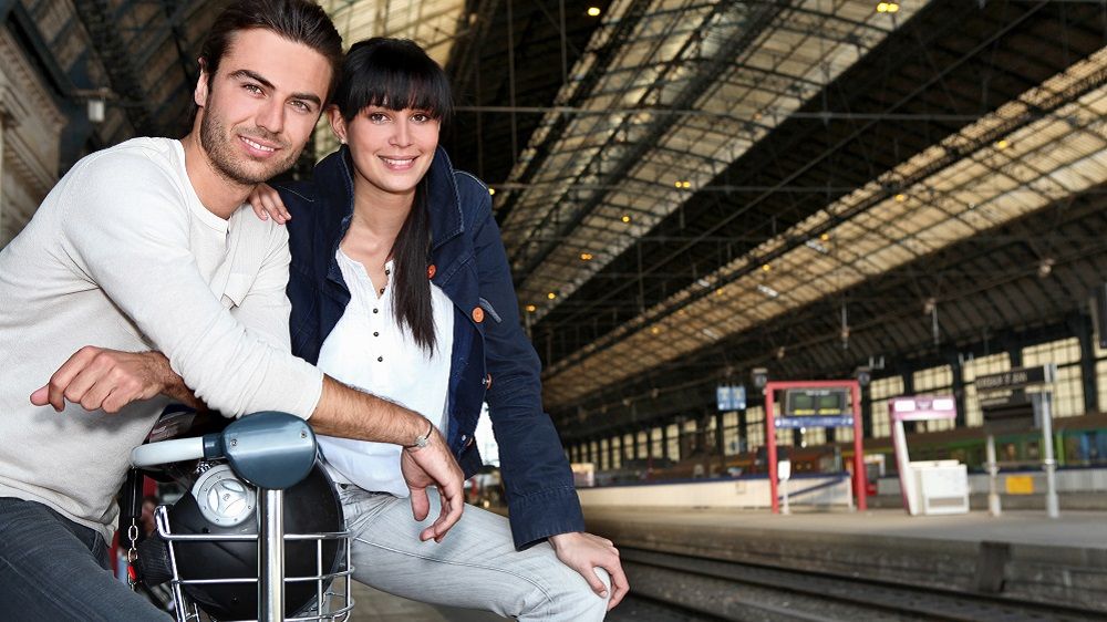 Paar wartet auf dem Bahnhof auf den Zug